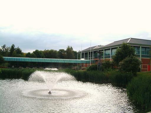 Photograph of a lake, fountain and building at the Loughborough campus