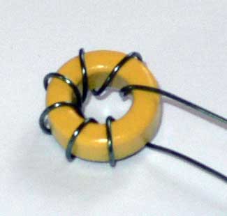 Photograph of yellow torroid with turns of wire wound on it